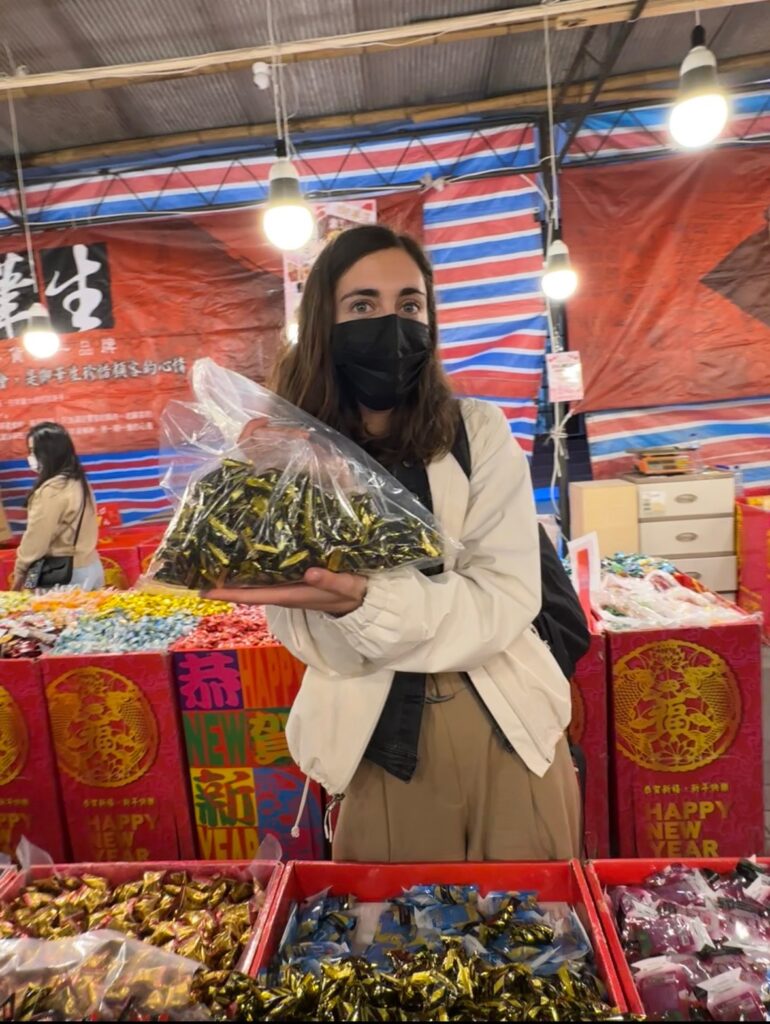Picture of me holding up a bag full of the black sesame candy from Dihua Street.